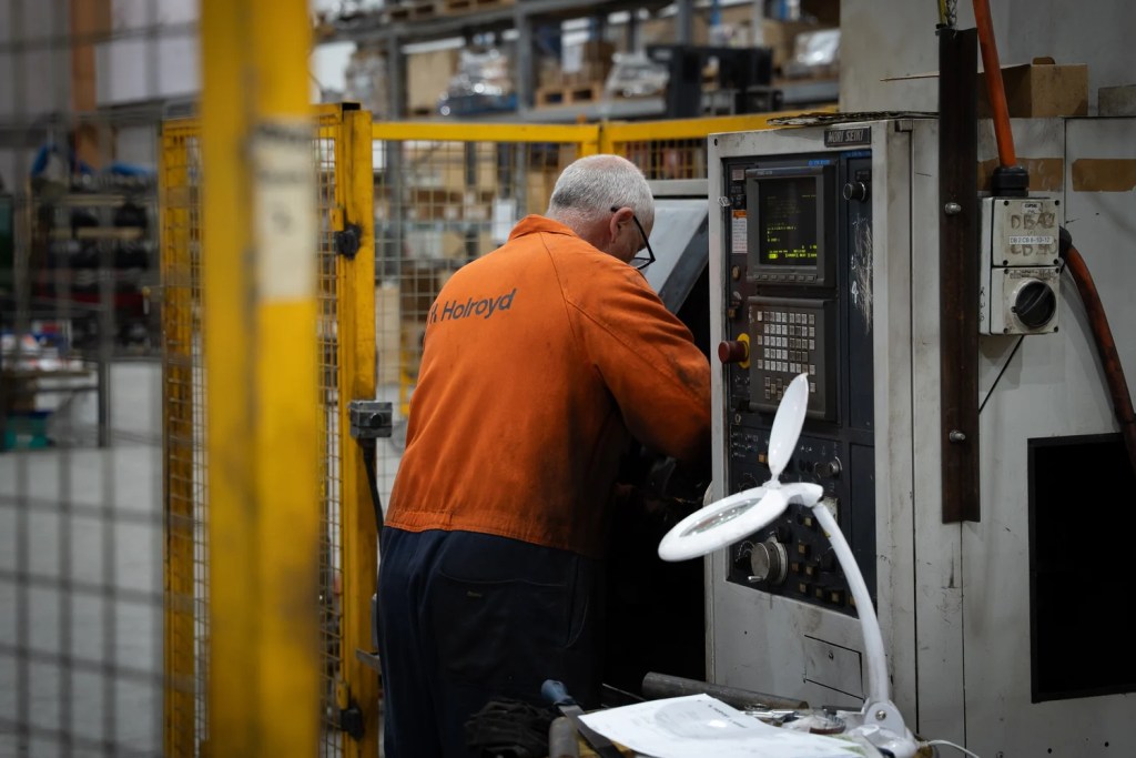 A Holroyd machinist setting up a job at the CNC lathe controls