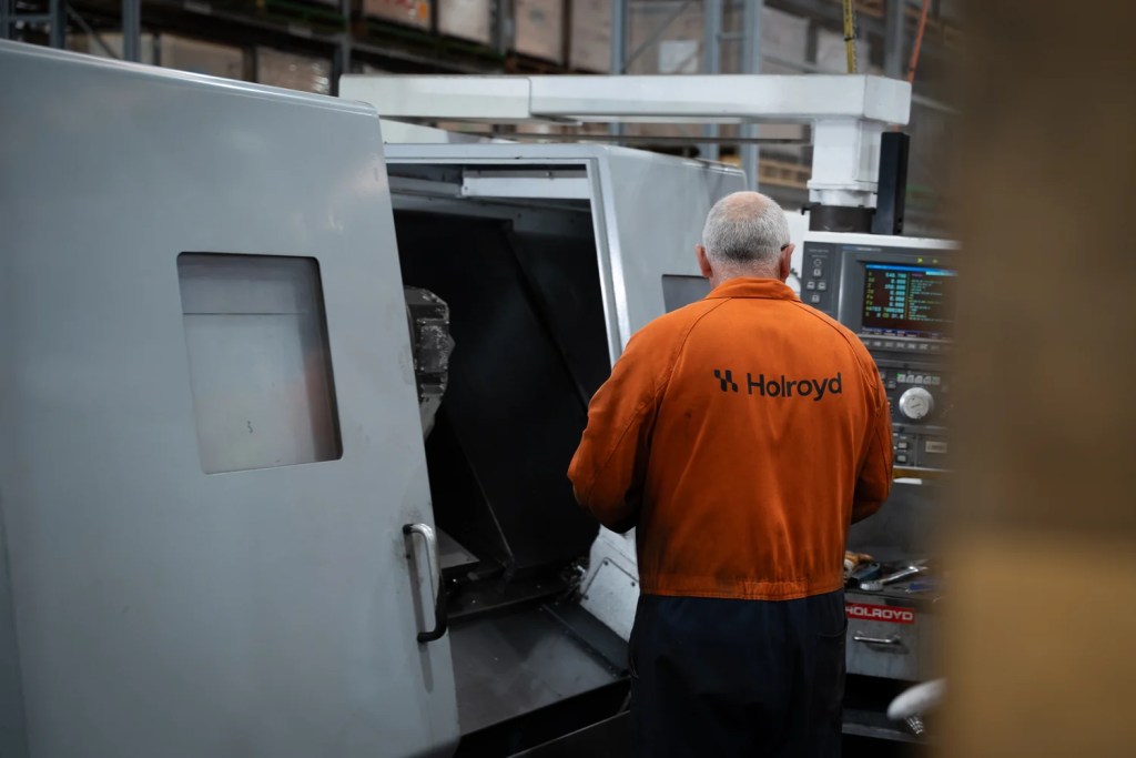 A Holroyd machinist at the CNC lathe control panel